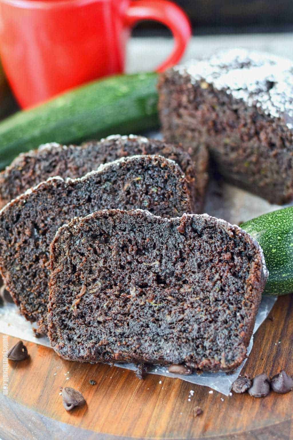 chocolate zucchini bread on a cutting board with zucchini