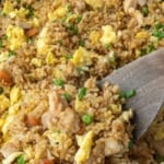 A spatula scooping up some chicken fried rice pinterest pin.