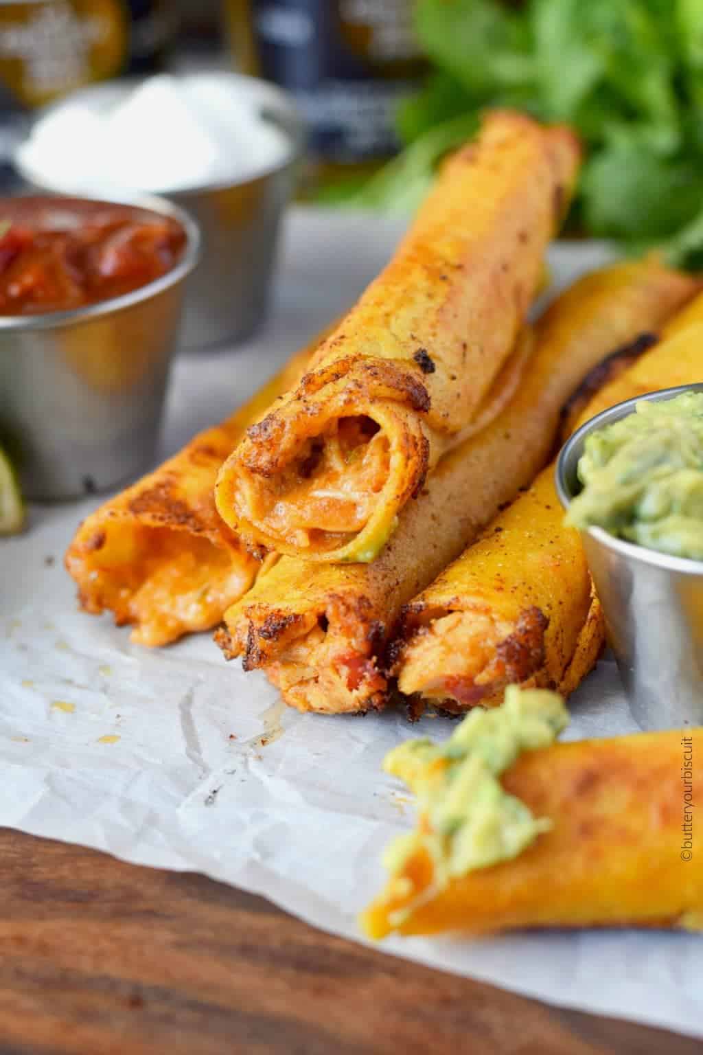 A close-up of taquitos with salsa.