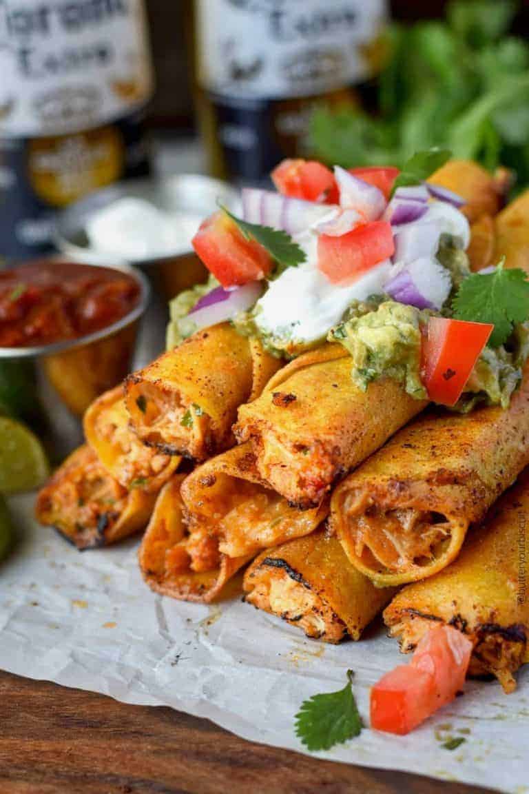 pepper jack chicken taquitos stacked with sour cream, guacamole and pico de gallo on top
