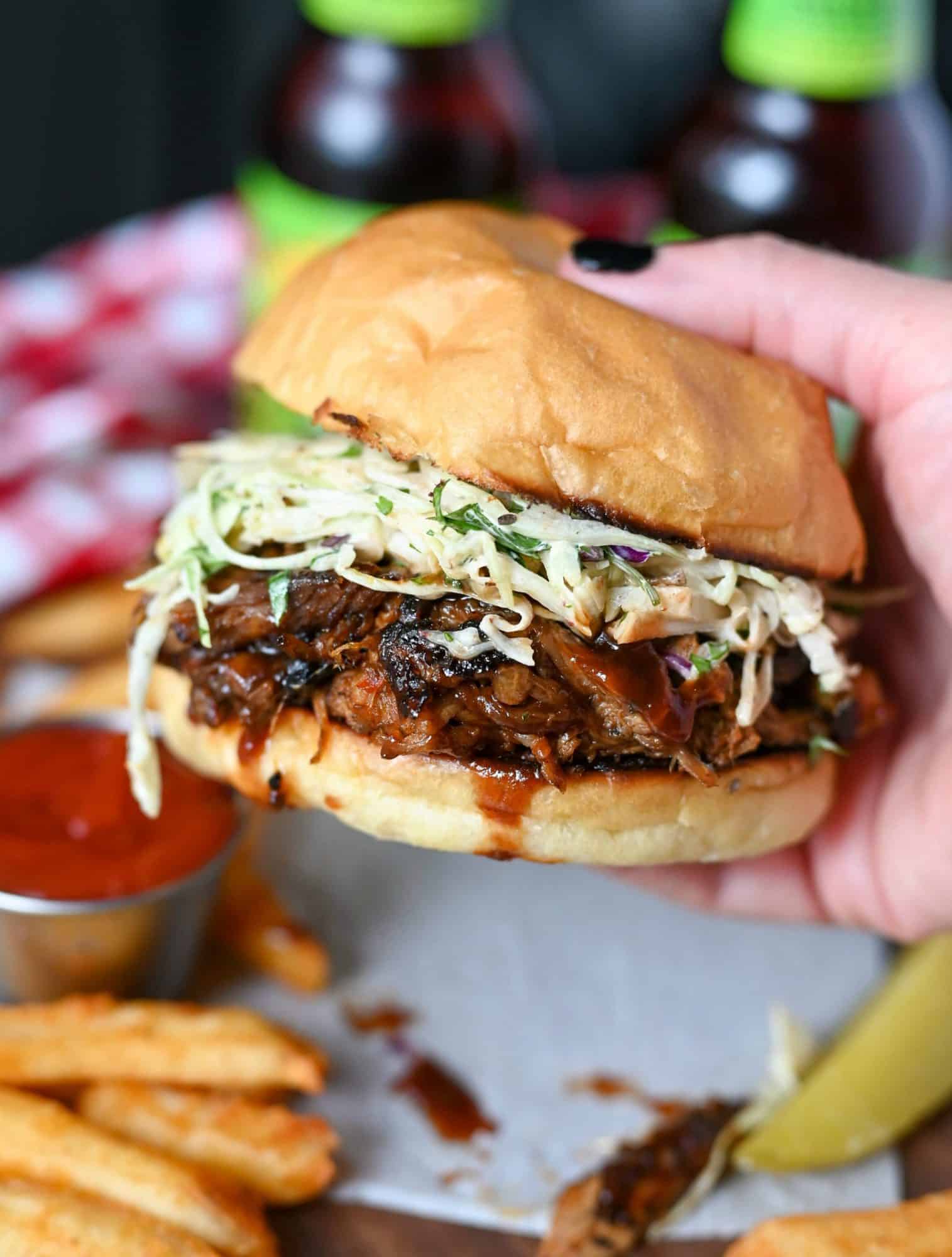 slow cooker pulled pork sandwich with chipotle slaw being picked up.