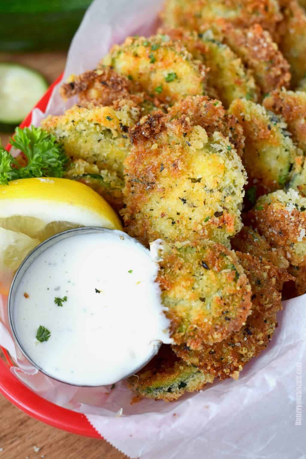 A basket of zucchini crisps with ranch.