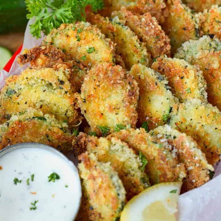 zucchini parmesan crisps in a basket with a side of ranch dressing