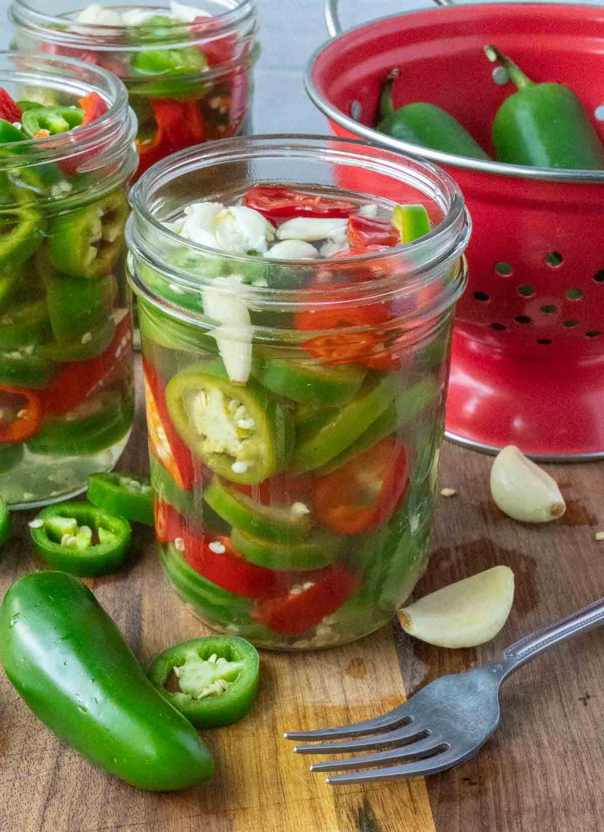 Vinegar poured into jars with sliced jalapenos.