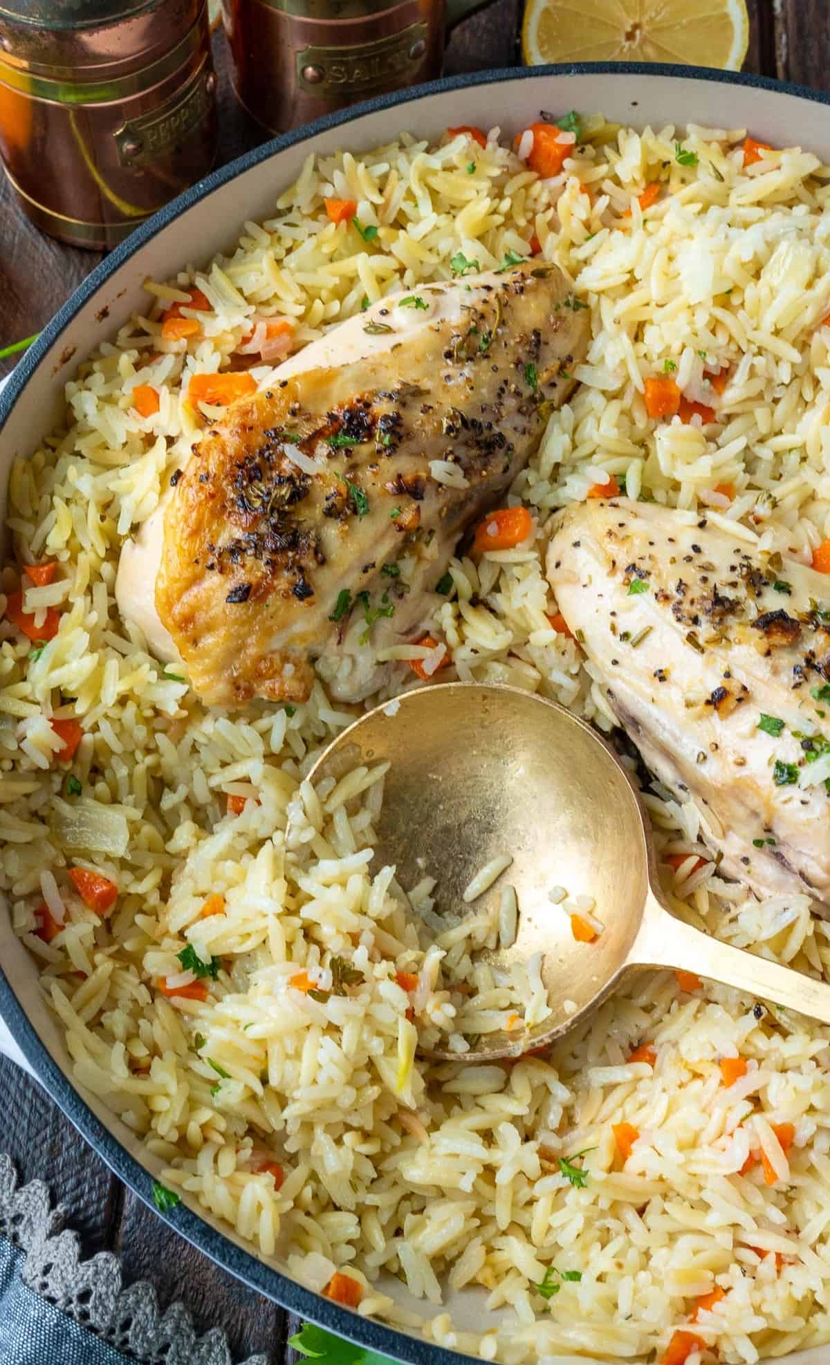 Lemon herb chicken in a skillet with rice pilaf.