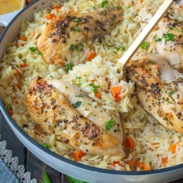 A spoon scooping up some rice pilaf and chicken breast.