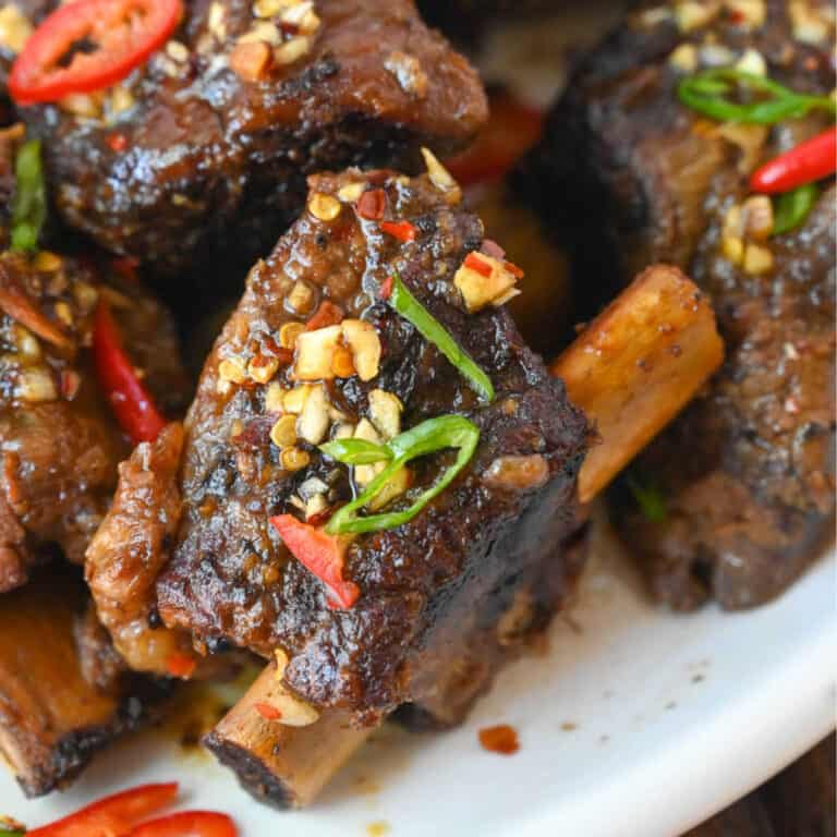 Short ribs on a white platter.