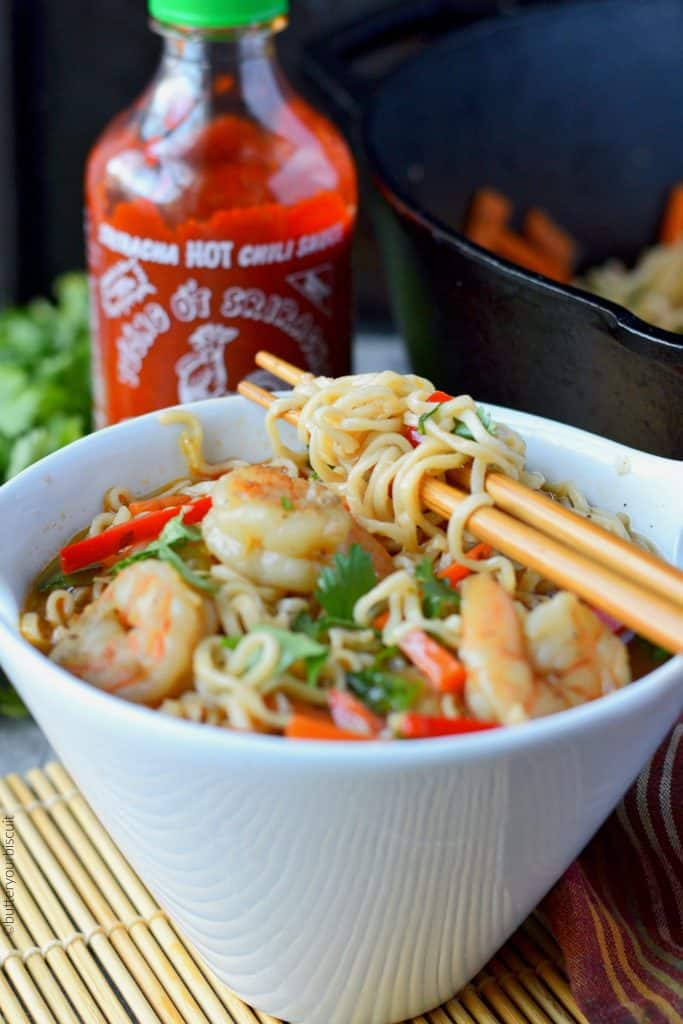 Spicy shrimp ramen bowl with sriracha bottle