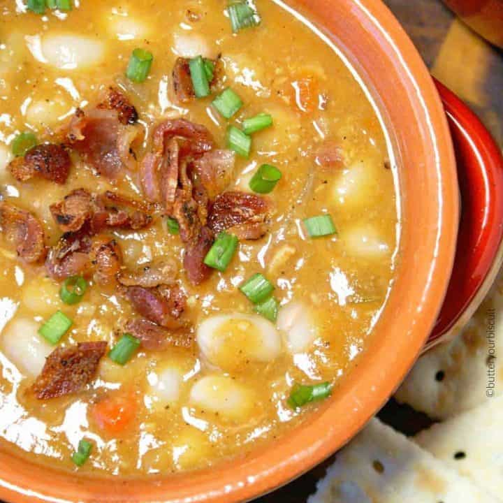 bean and bacon soup in a bowl with saltine crackers