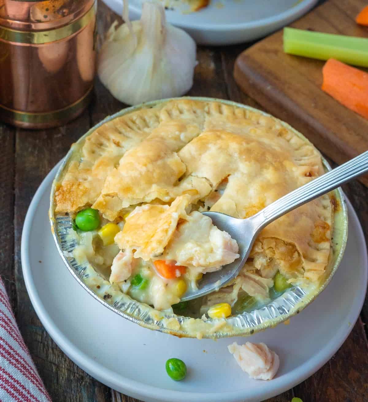 A spoon scooping out a bite of chicken pot pie.