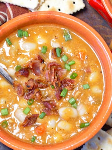 A close up photo of slow cooker bean and bacon soup.