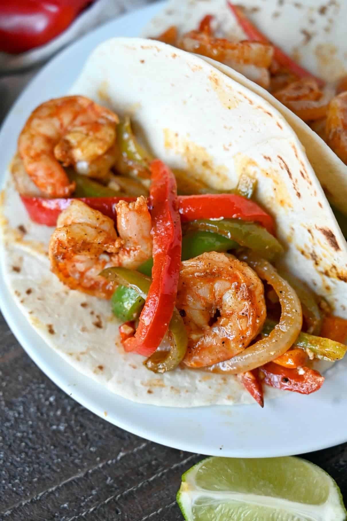 Shrimp, peppers placed in a flour tortilla.