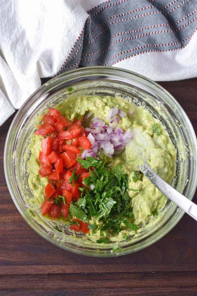 A bowl of guacamole is mixed together.