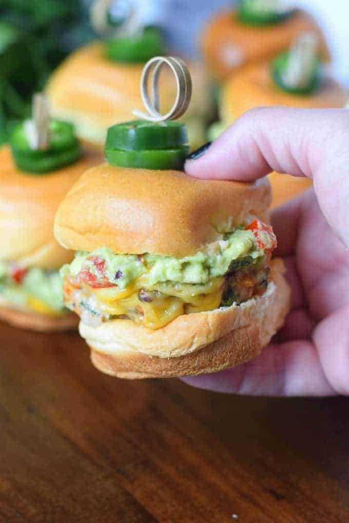 A chicken burger slider is being held.