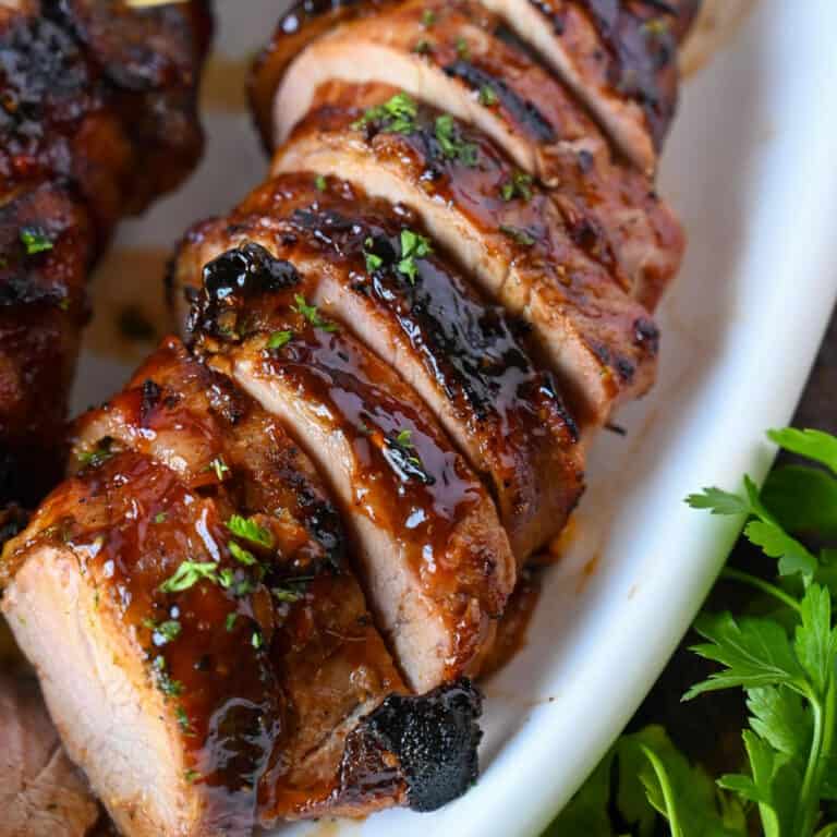 Bacon wrapped pork tenderloin cut into slices.