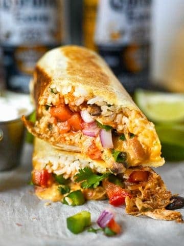Slow cooker chicken burrito cut in half and stalked on top of each other.