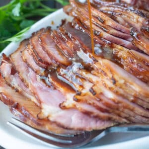 Spiral glazed ham sliced on a platter.
