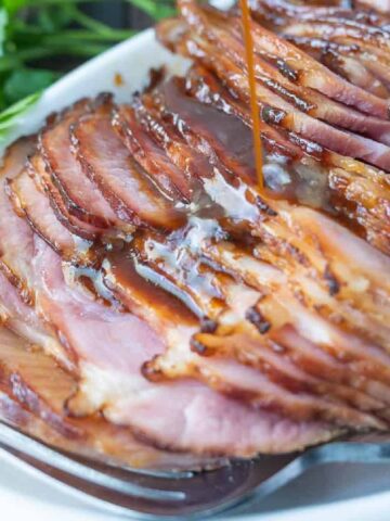 Spiral glazed ham sliced on a platter.
