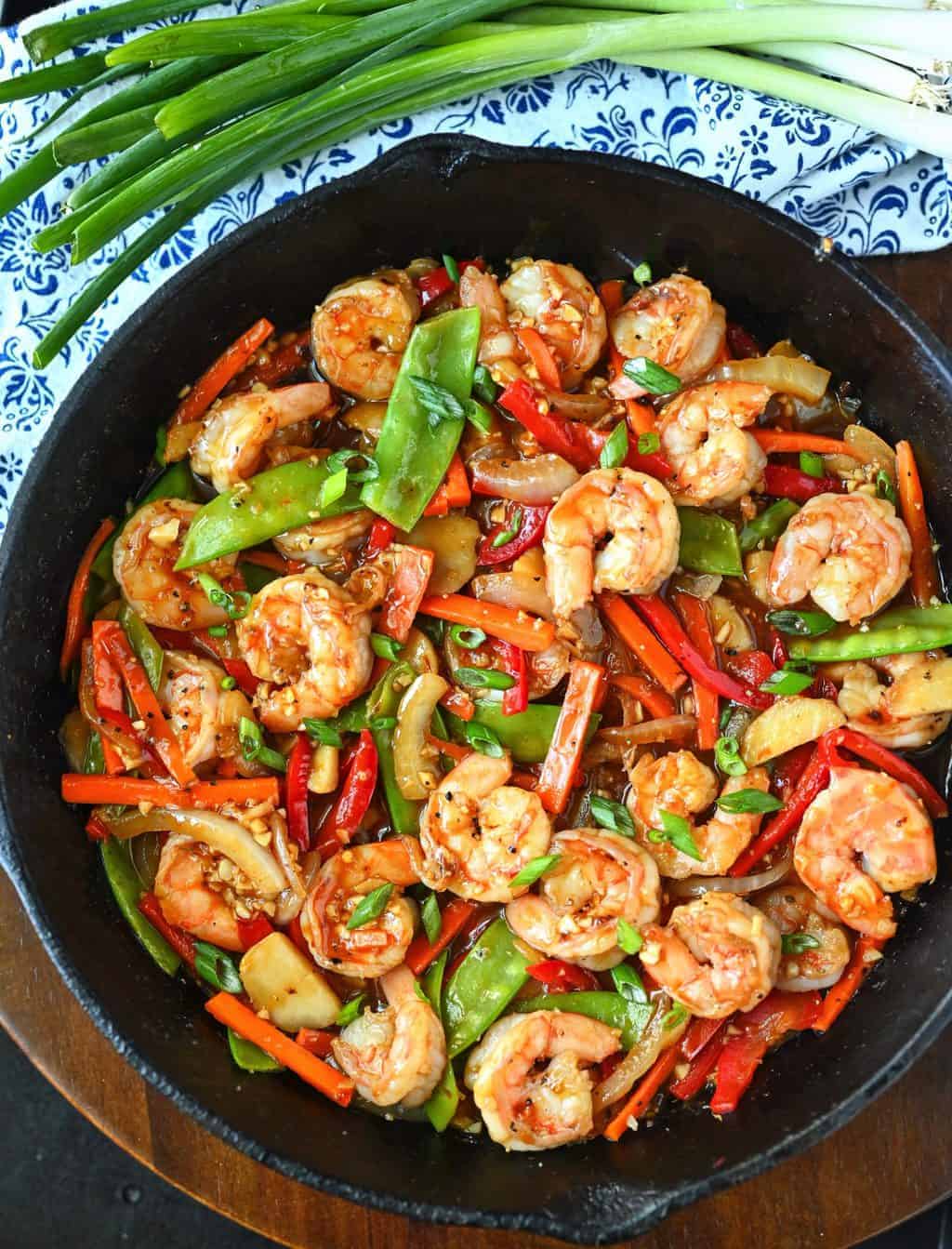 A skillet filled with shrimp and vegetables.