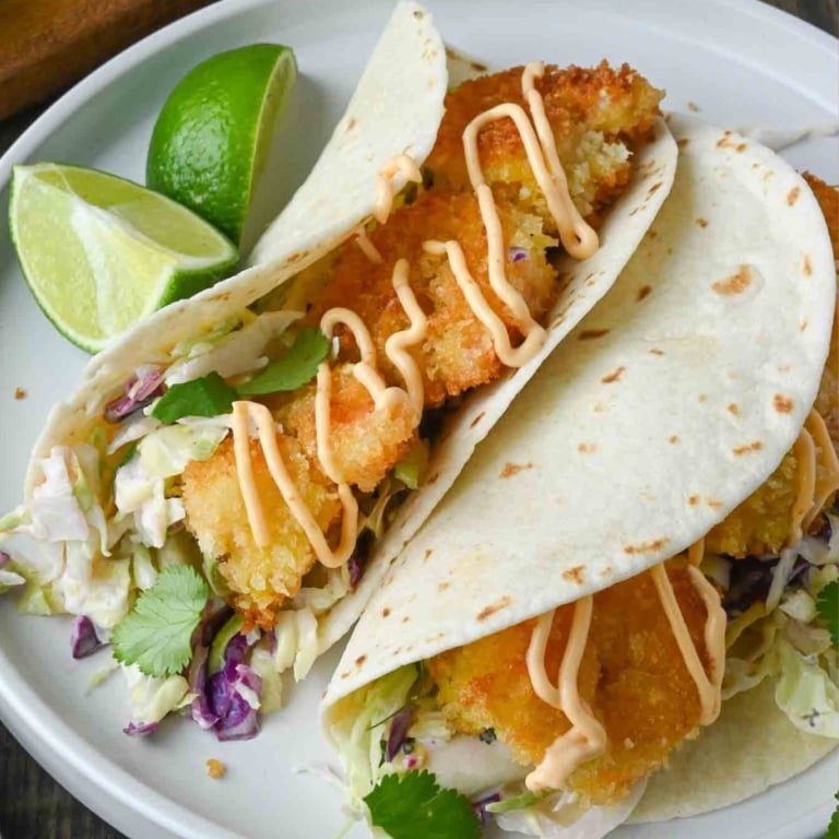 Crispy shrimp tacos on a white plate.
