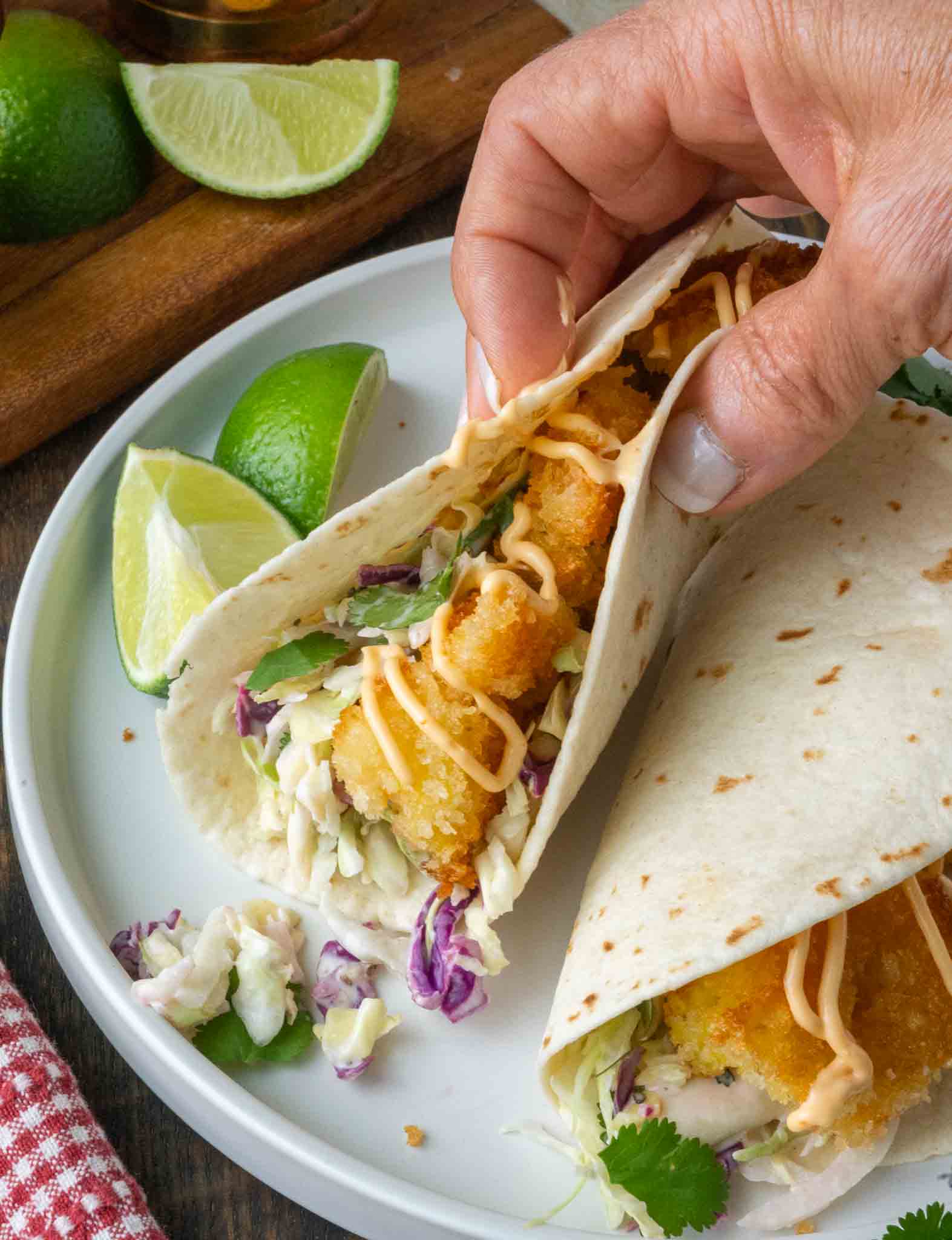 A crispy shrimp taco being picked up.