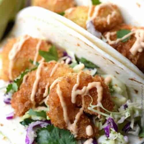 https://butteryourbiscuit.com/wp-content/uploads/2017/04/crispy-shrimp-tacos-with-cilantro-lime-slaw-and-sriracha-sauce-1-500x500.jpg