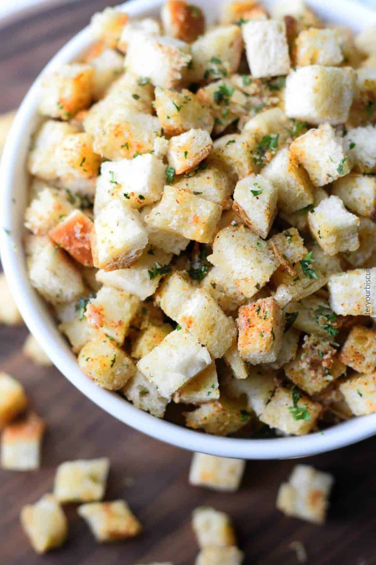 A close up photo of homade seasoned croutons in a bowl.