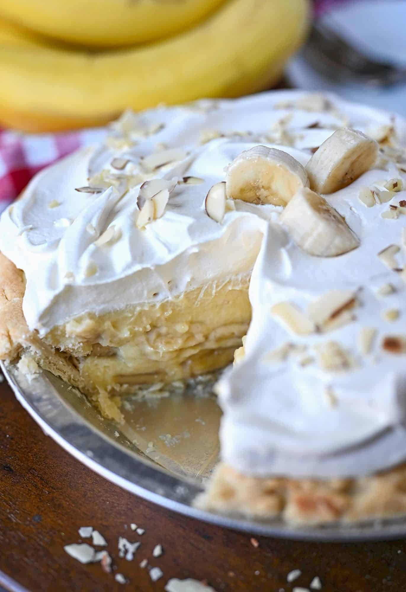 Whole banana cream pie with a slice cut out. 