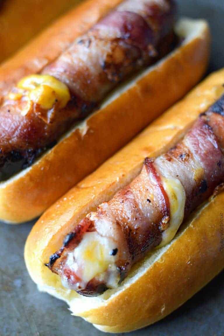 Bacon wrapped hot dogs stuffed with cheese in soft buns