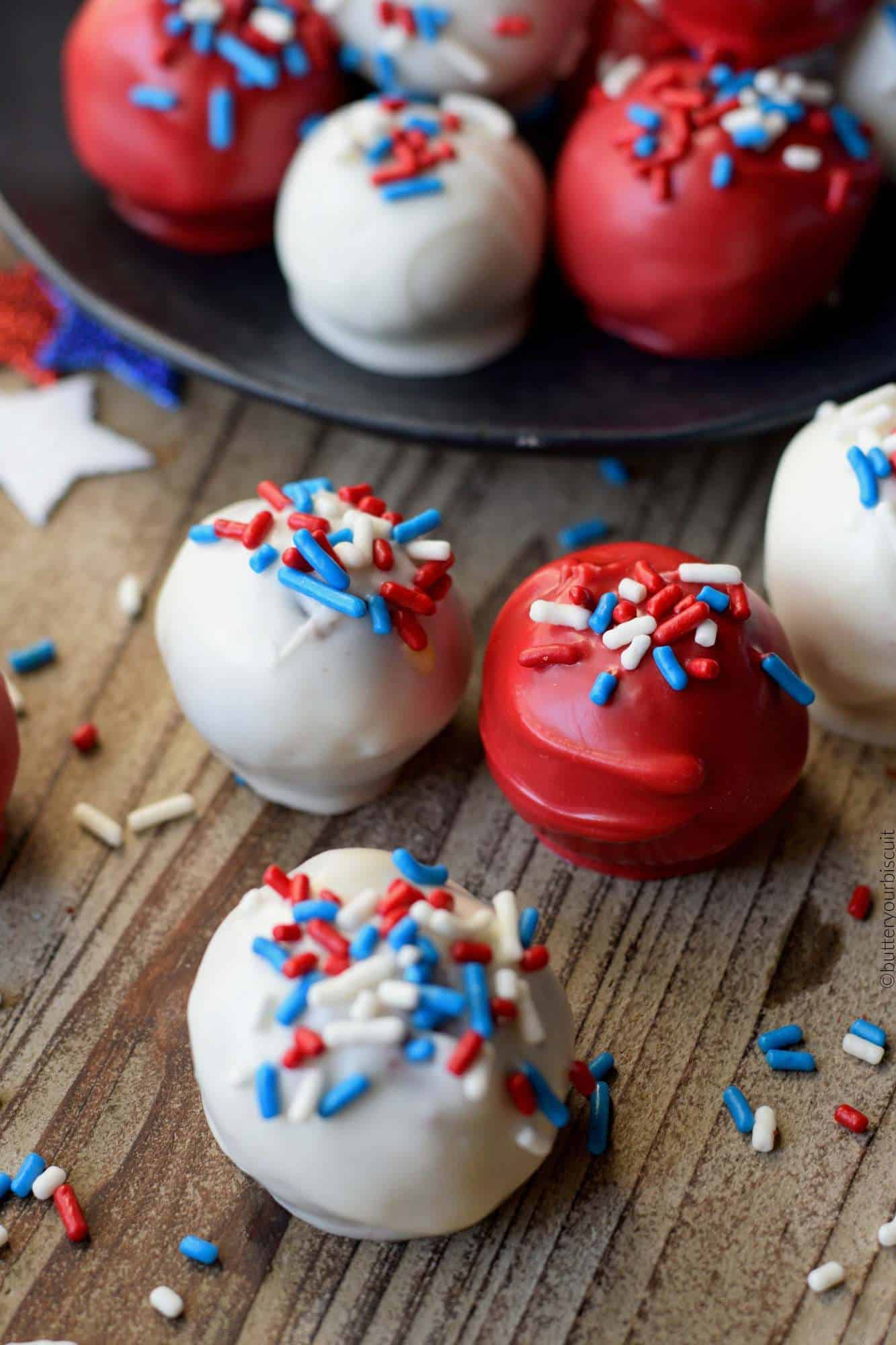 A close up photo of three cake balls with sprinkles on top.