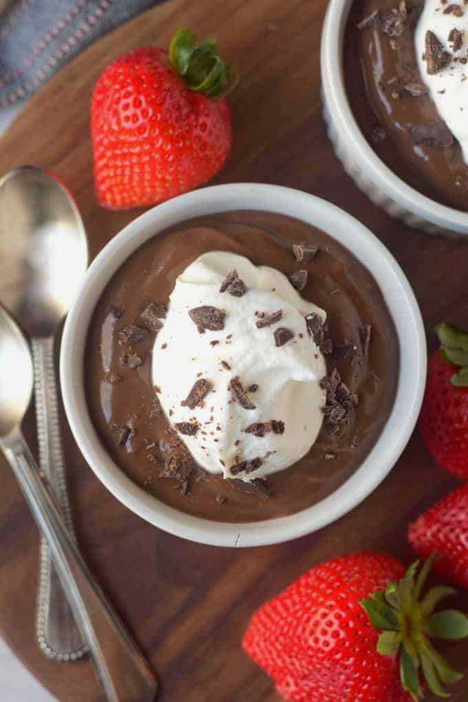 A bowl of chocolate pudding with whipped cream on top.