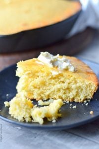 piece of sweet honey cornbread on a black plate