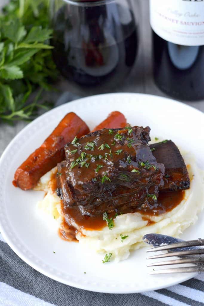 Beef short ribs braised in red wine with carrots on a plate