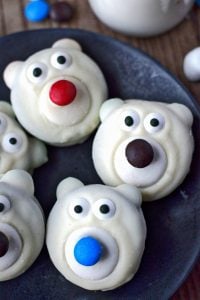 Polar bear cookies on a black plate with milk