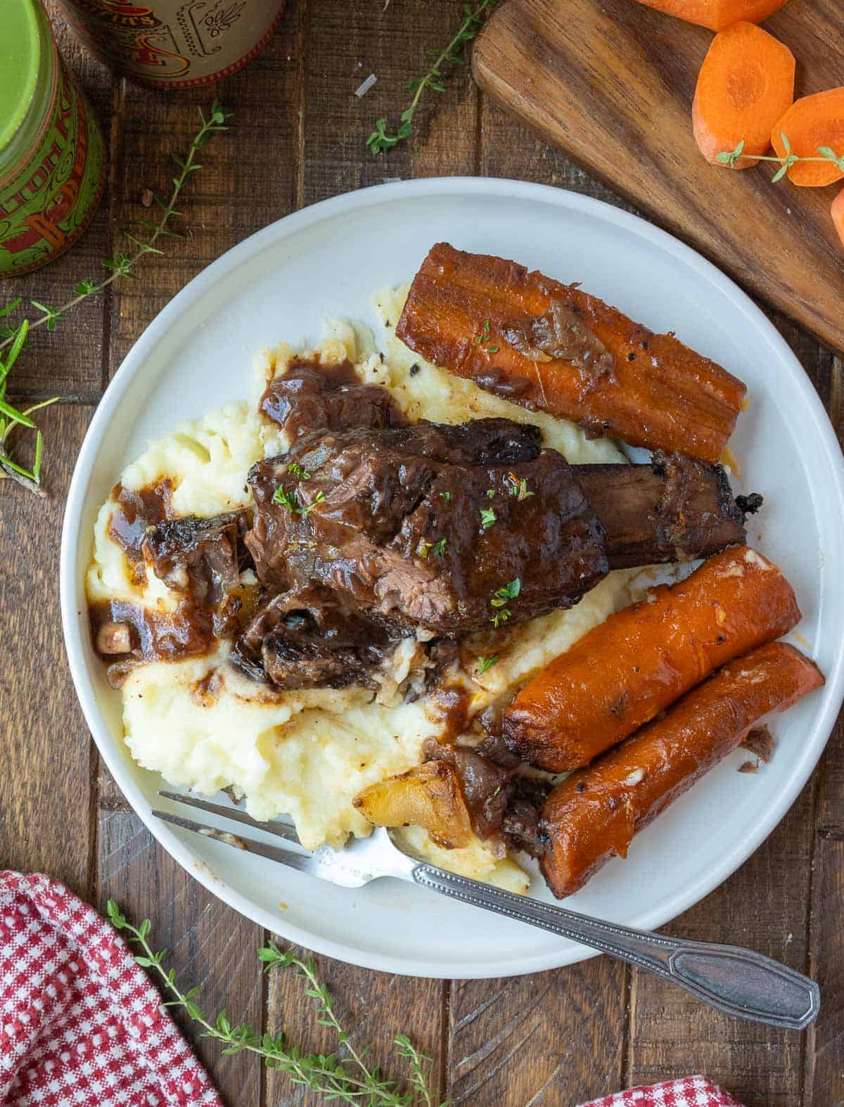 Short ribs on mashed potatoes with carrots.