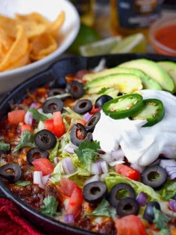 Loaded taco dip in a skillet with chips