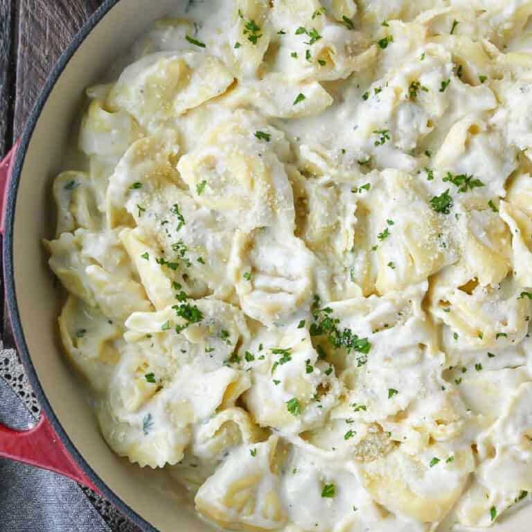 Garlic alfredo cheese tortellini in a skillet.