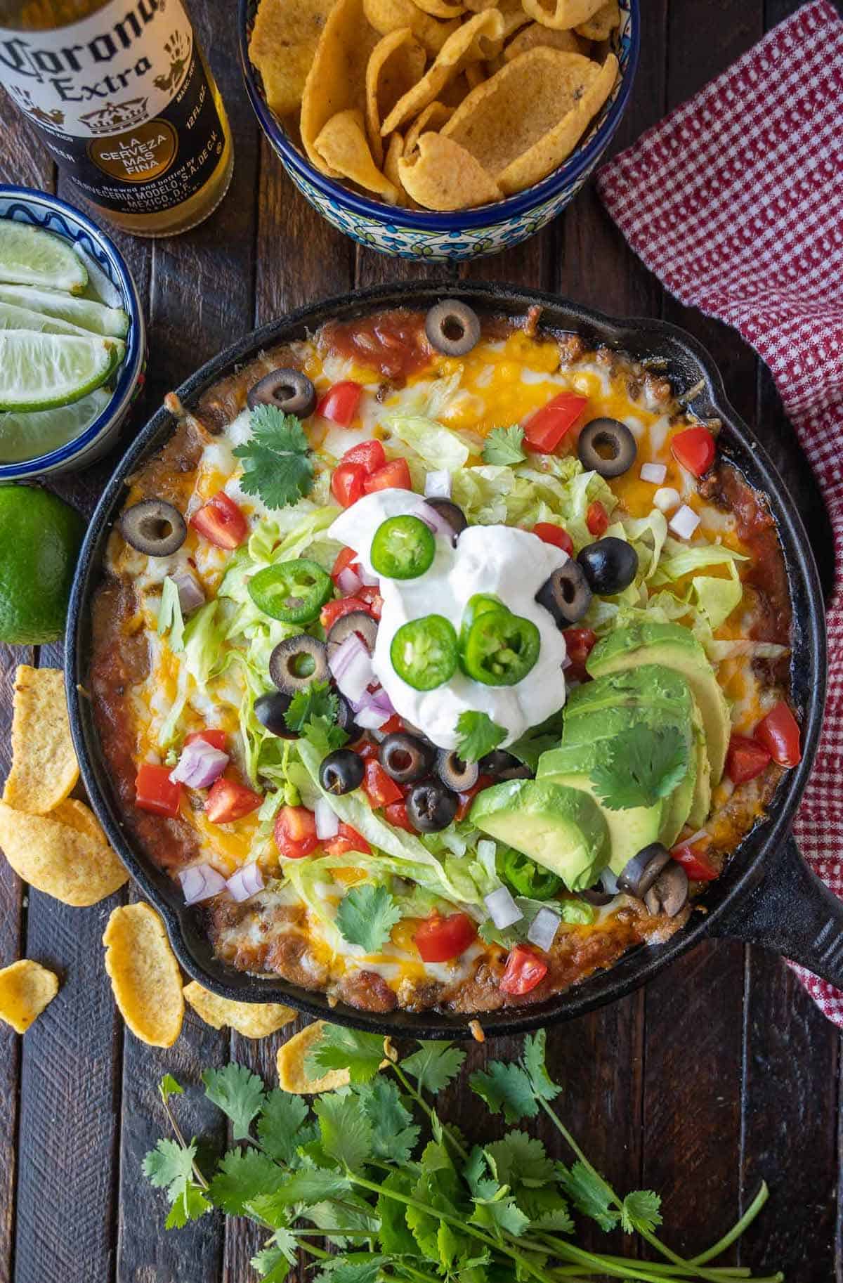 Loaded taco dip in a cast iron skillet with Fritos.