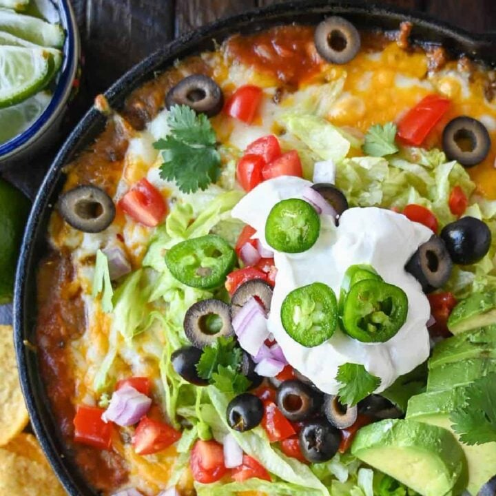 loaded taco dip in a cast iron skillet.