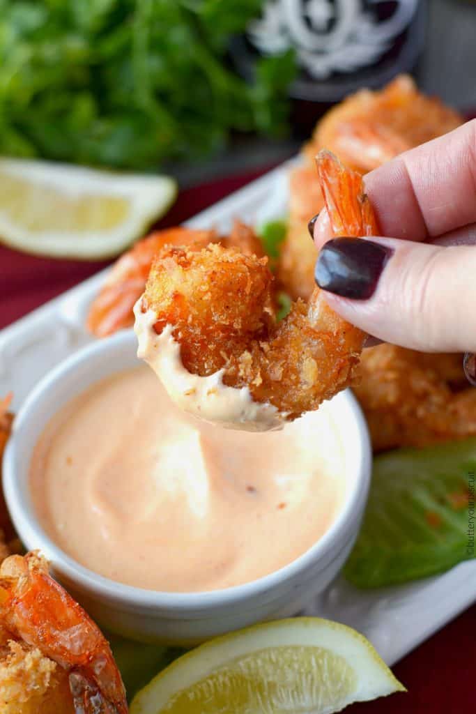 A close up of a plate of food, with Shrimp and Coconut and sauce.