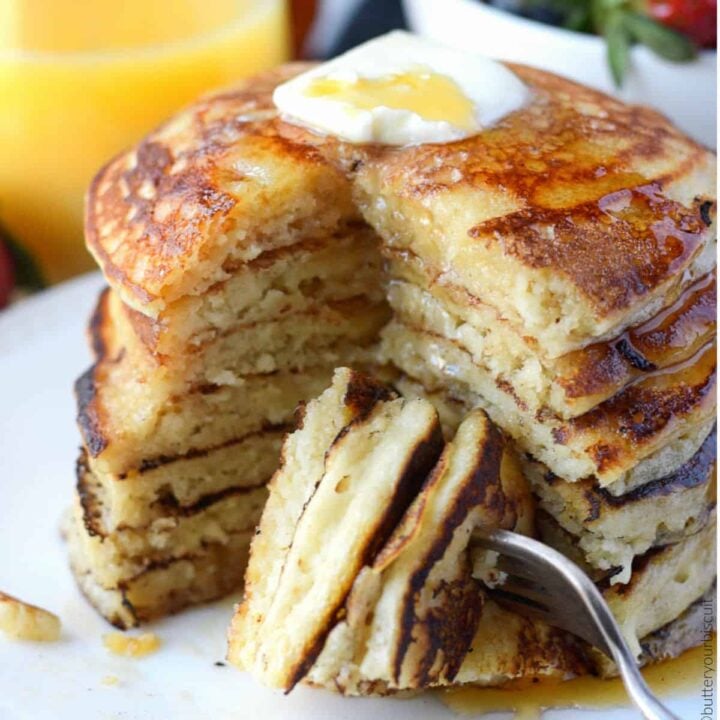 A stack of pancakes with a bite on a fork.