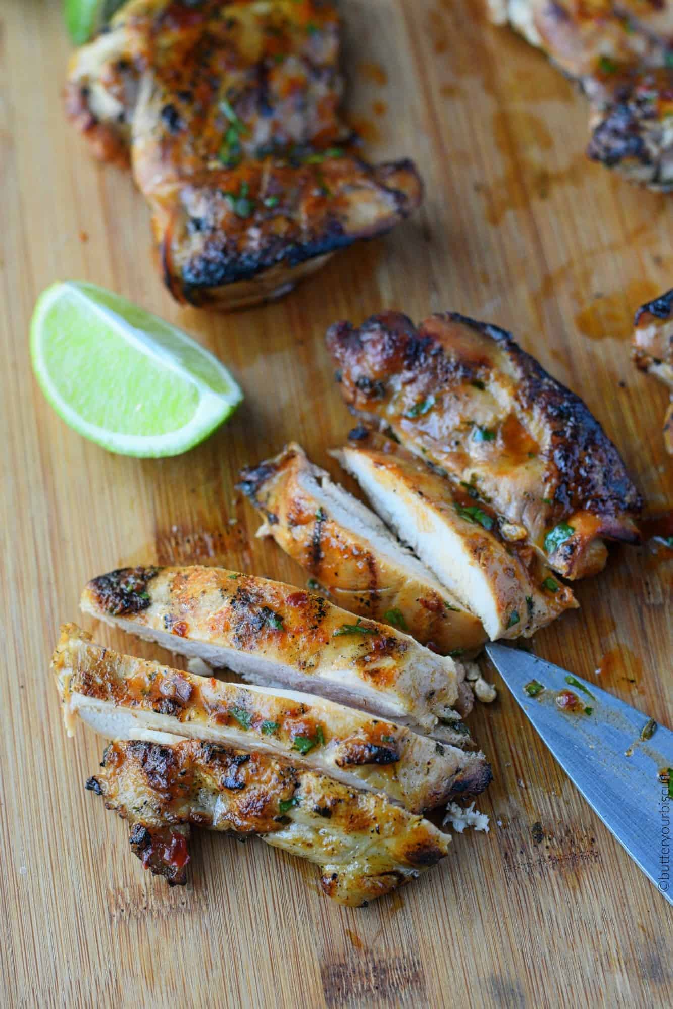 Tequila lime chicken thighs being sliced on a cutting board.