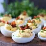 Chipotle bacon deviled eggs served on a small cutting board