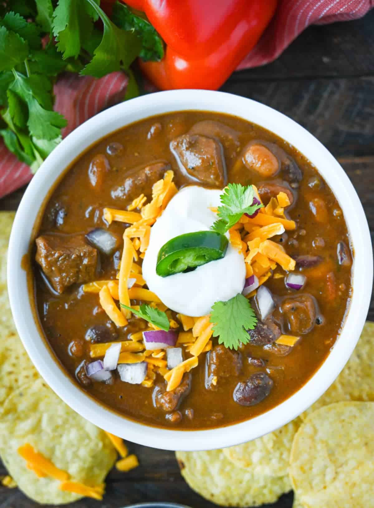 Steak chili with shredded cheese, onions , sour cream and cilantro on top.