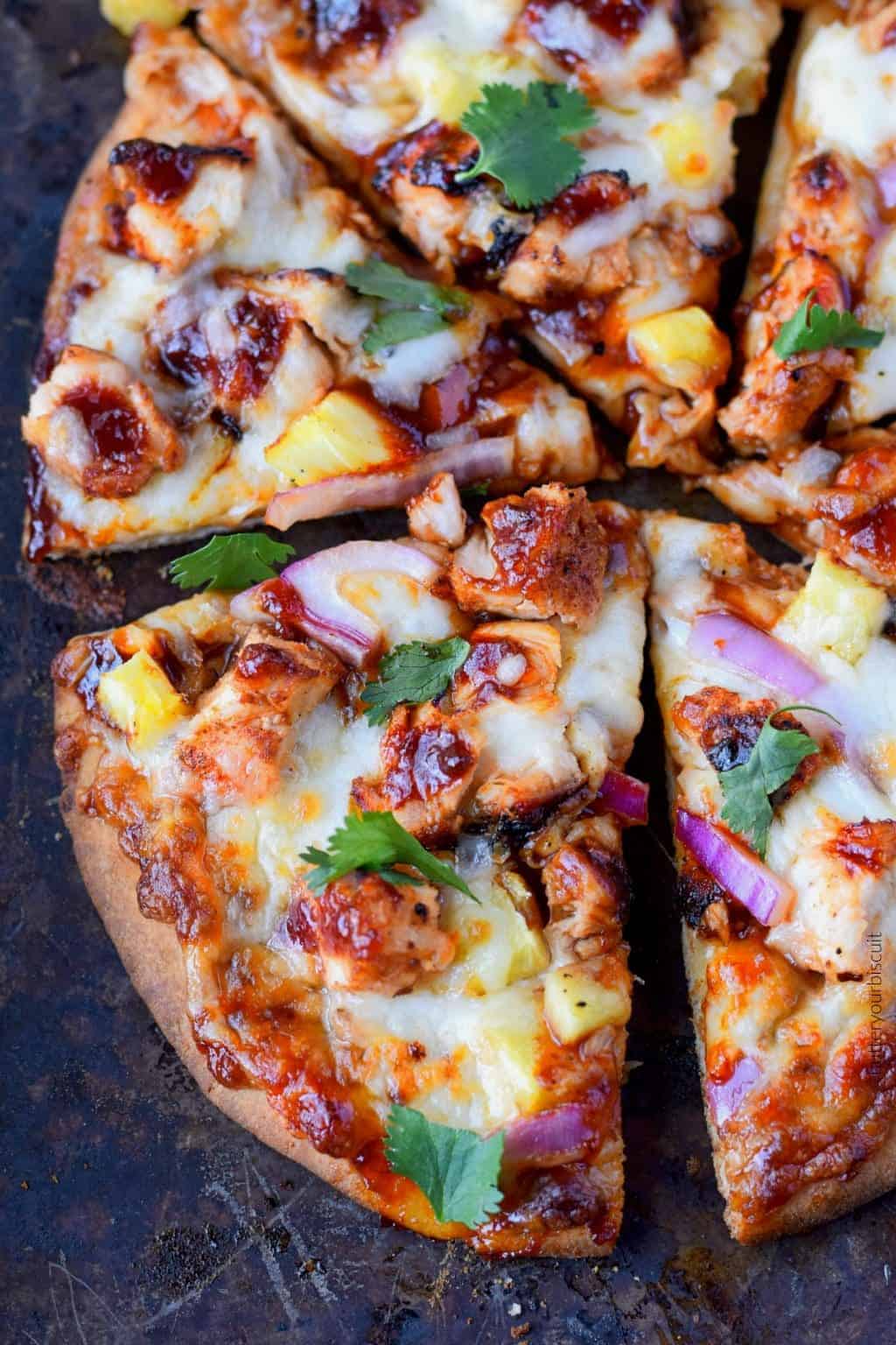 A close up photo of a slice of Hawaiian bbq chicken flatbread.