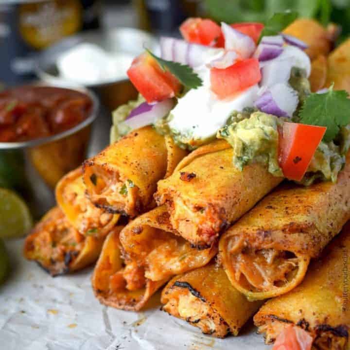 pepper jack chicken taquitos stacked with sour cream, guacamole and pico de gallo on top