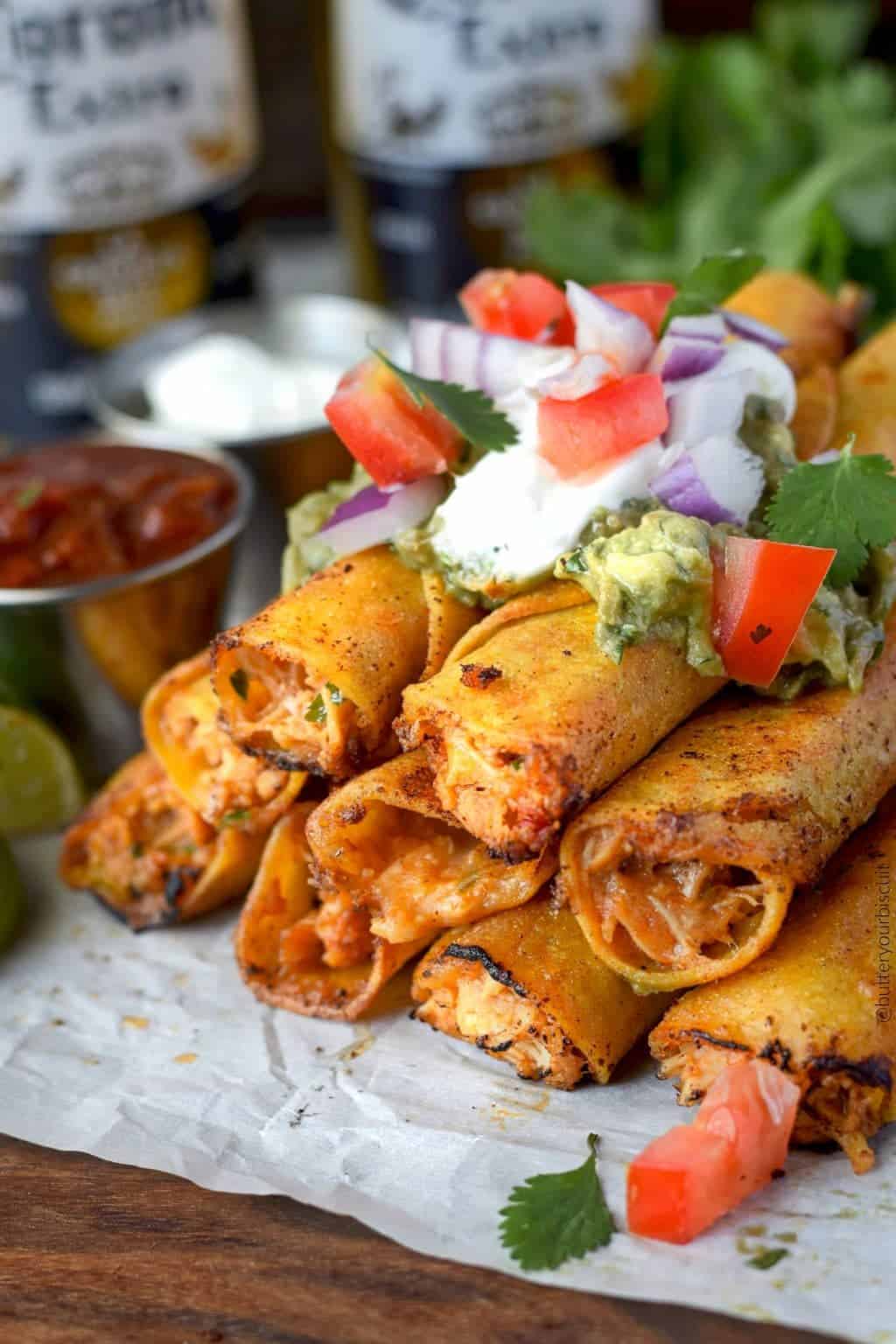 pepper jack chicken taquitos stacked with sour cream, guacamole and pico de gallo on top