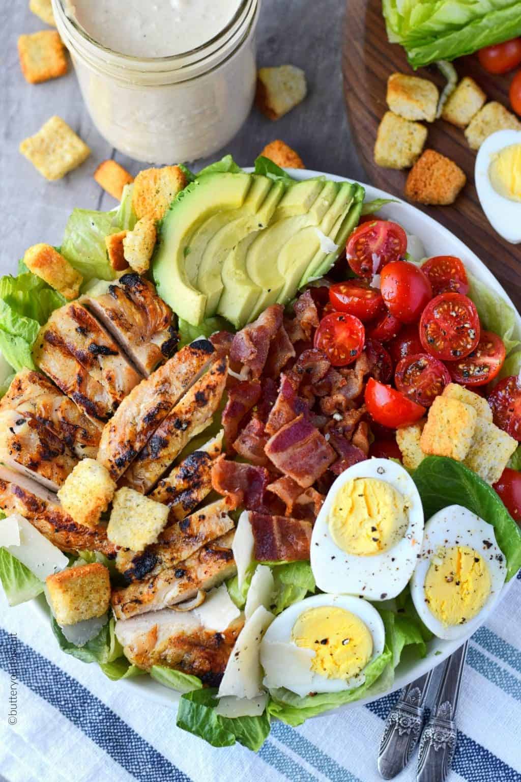 grilled chicken avocado salad in a white bowl