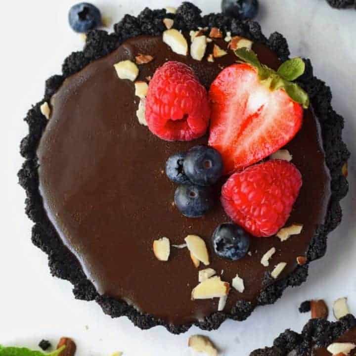 No bake chocolate mini tarts with strawberries, blueberries, rasberries and almond slivers on top