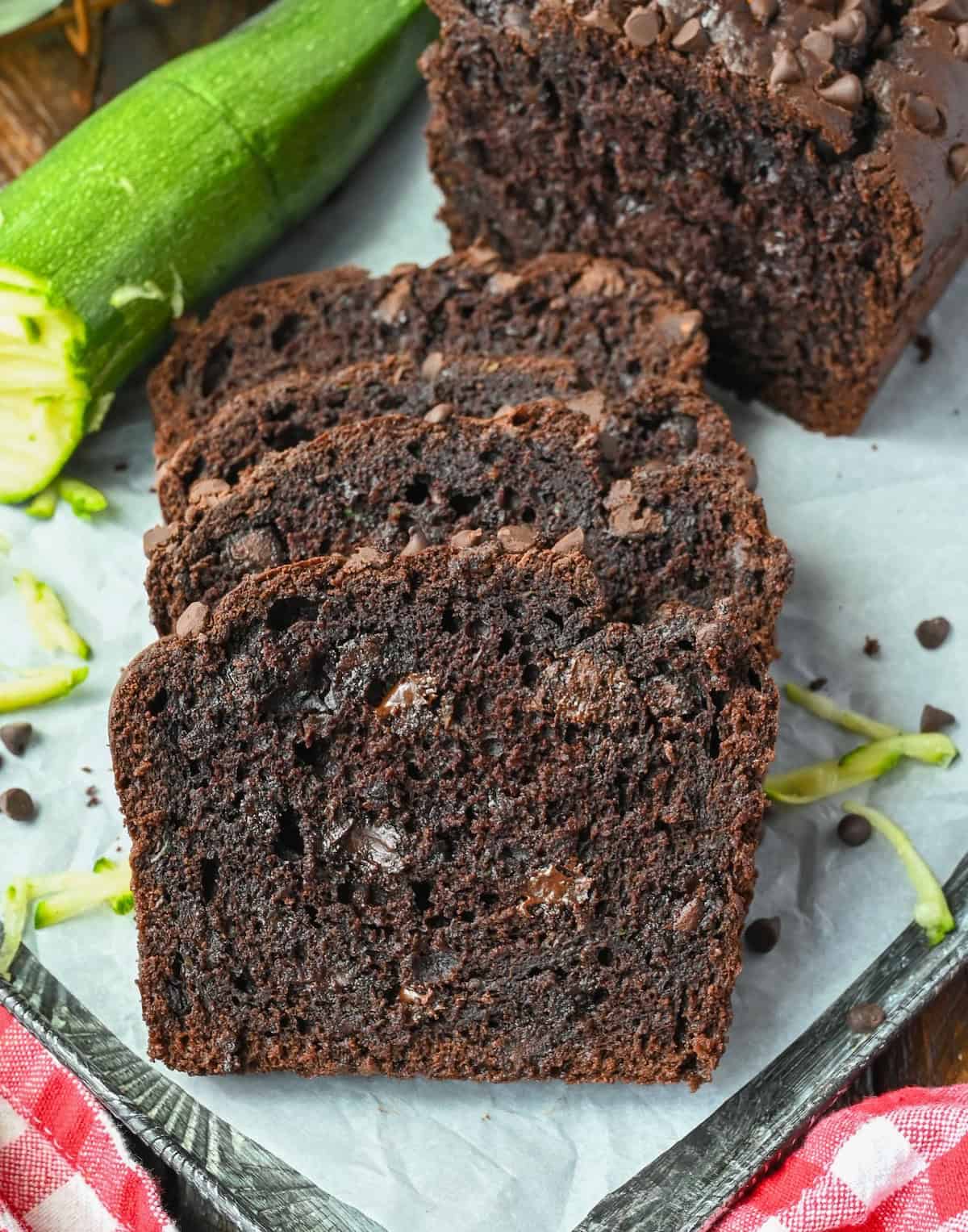 Slices of chocolate zucchini bread on a baking sheet.